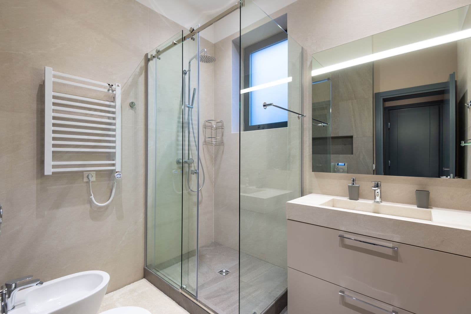 Modern remodeled bathroom with walk-in glass shower and floating vanity