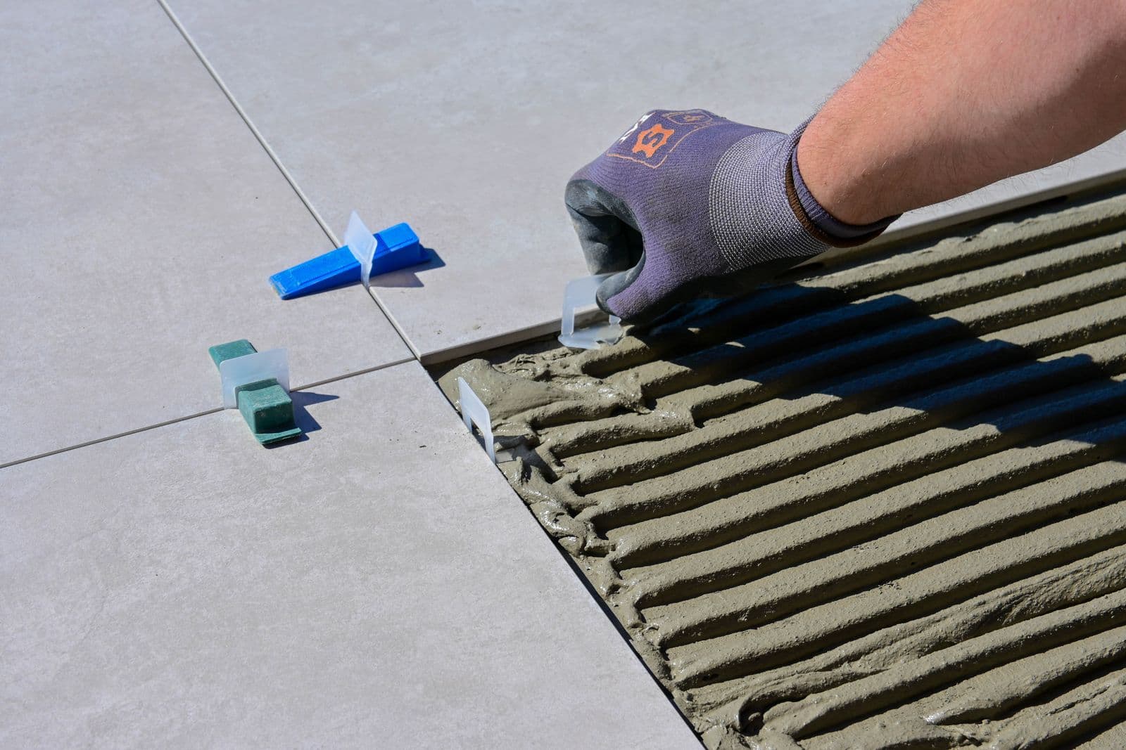 Craftsman installing tile with leveling clips