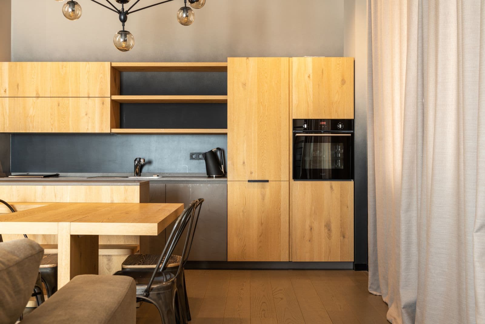 Renovated kitchen with warm oak cabinetry and integrated appliances